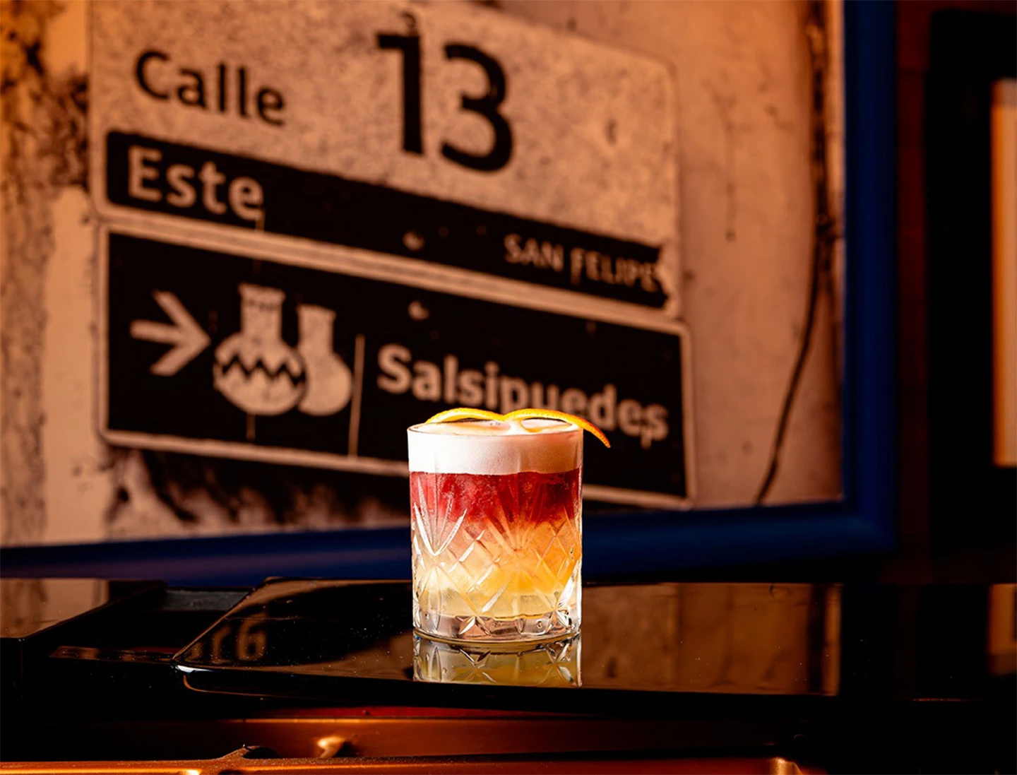 a glass with a drink on a counter