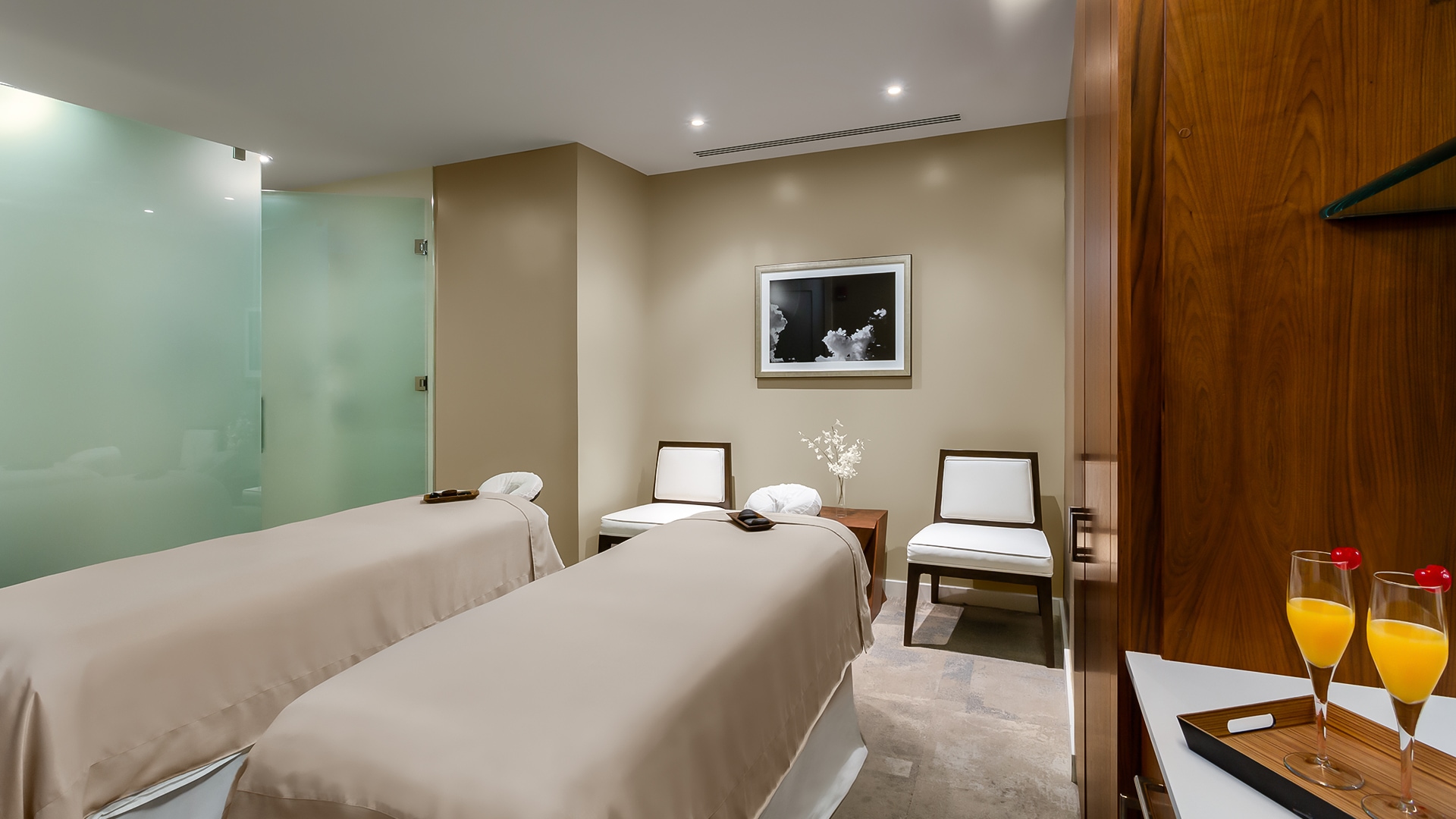 a room with two beds and chairs