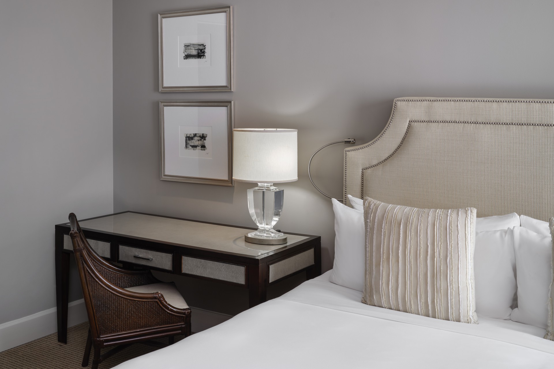 a bed with a lamp on a desk