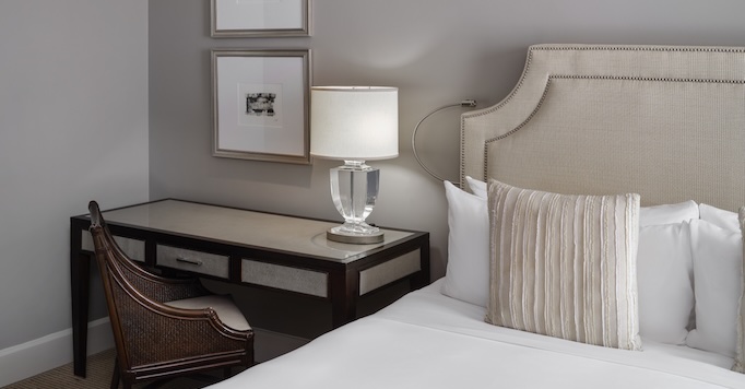 a lamp on a table next to a bed