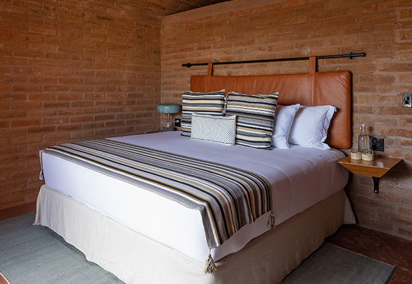 a bed with pillows and a lamp in a room