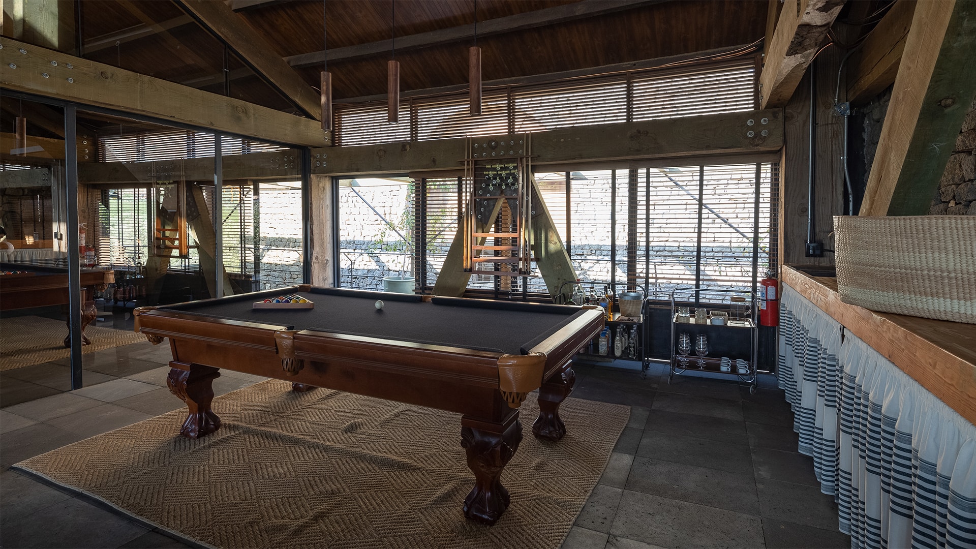 a pool table in a room with windows
