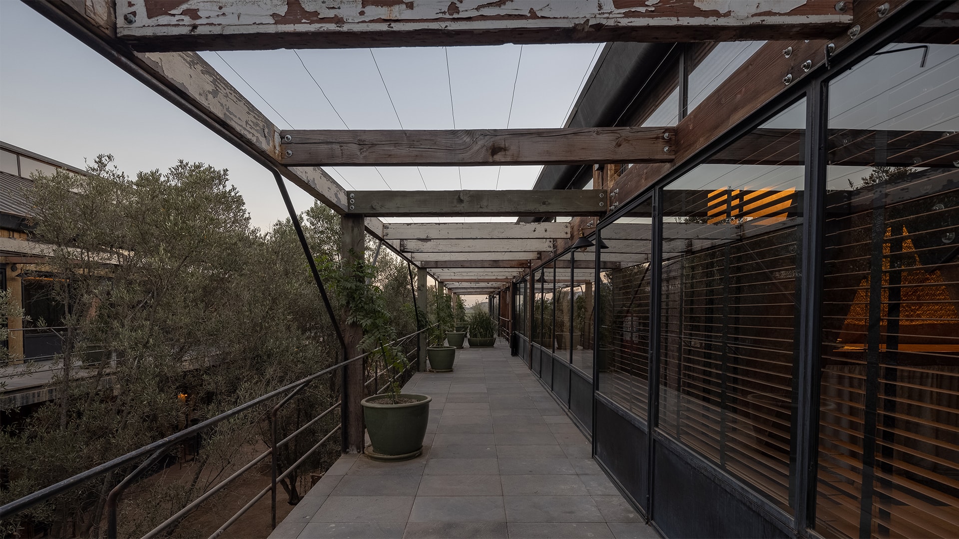 a walkway with glass windows and a wooden structure