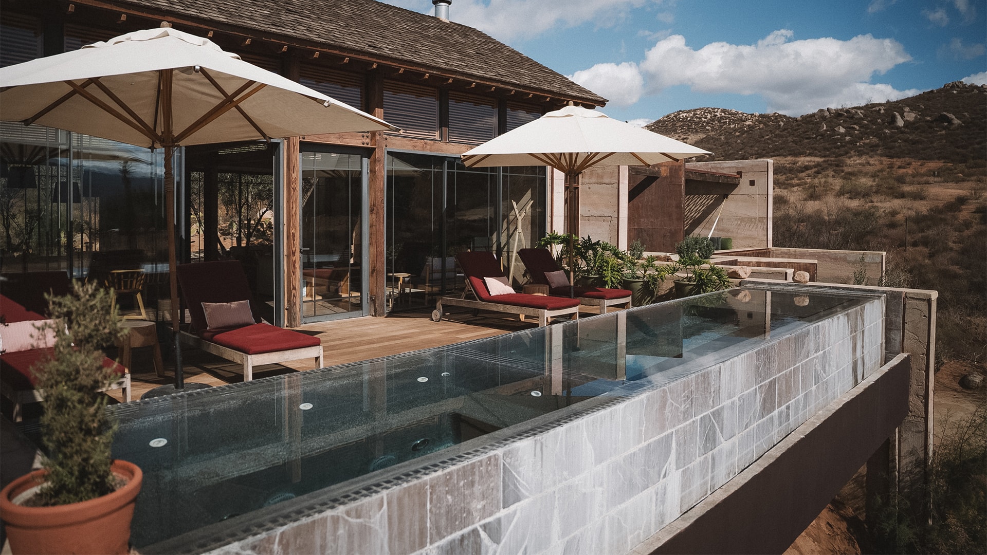 a pool with umbrellas and chairs on a deck