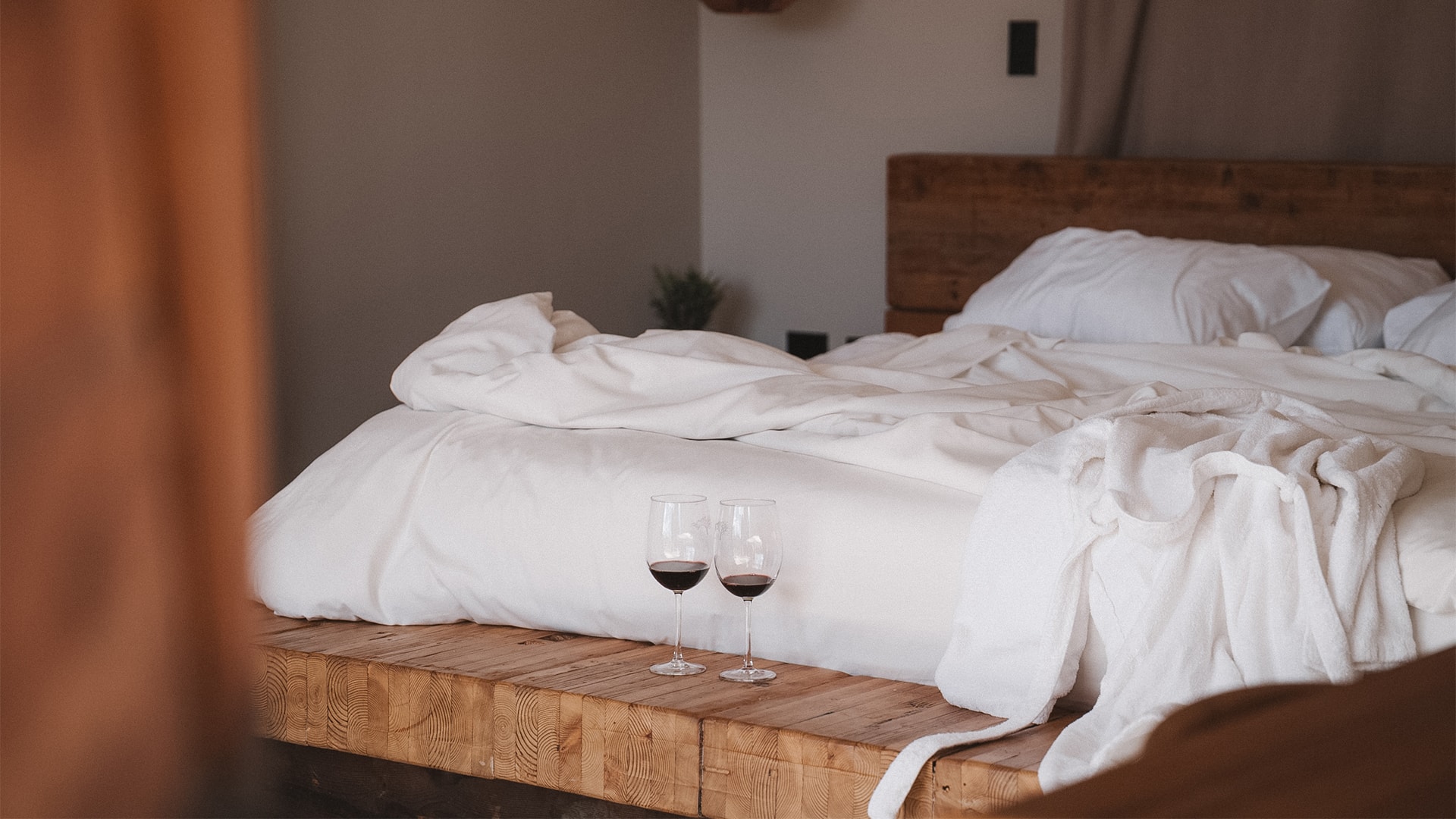 a couple of wine glasses on a bed