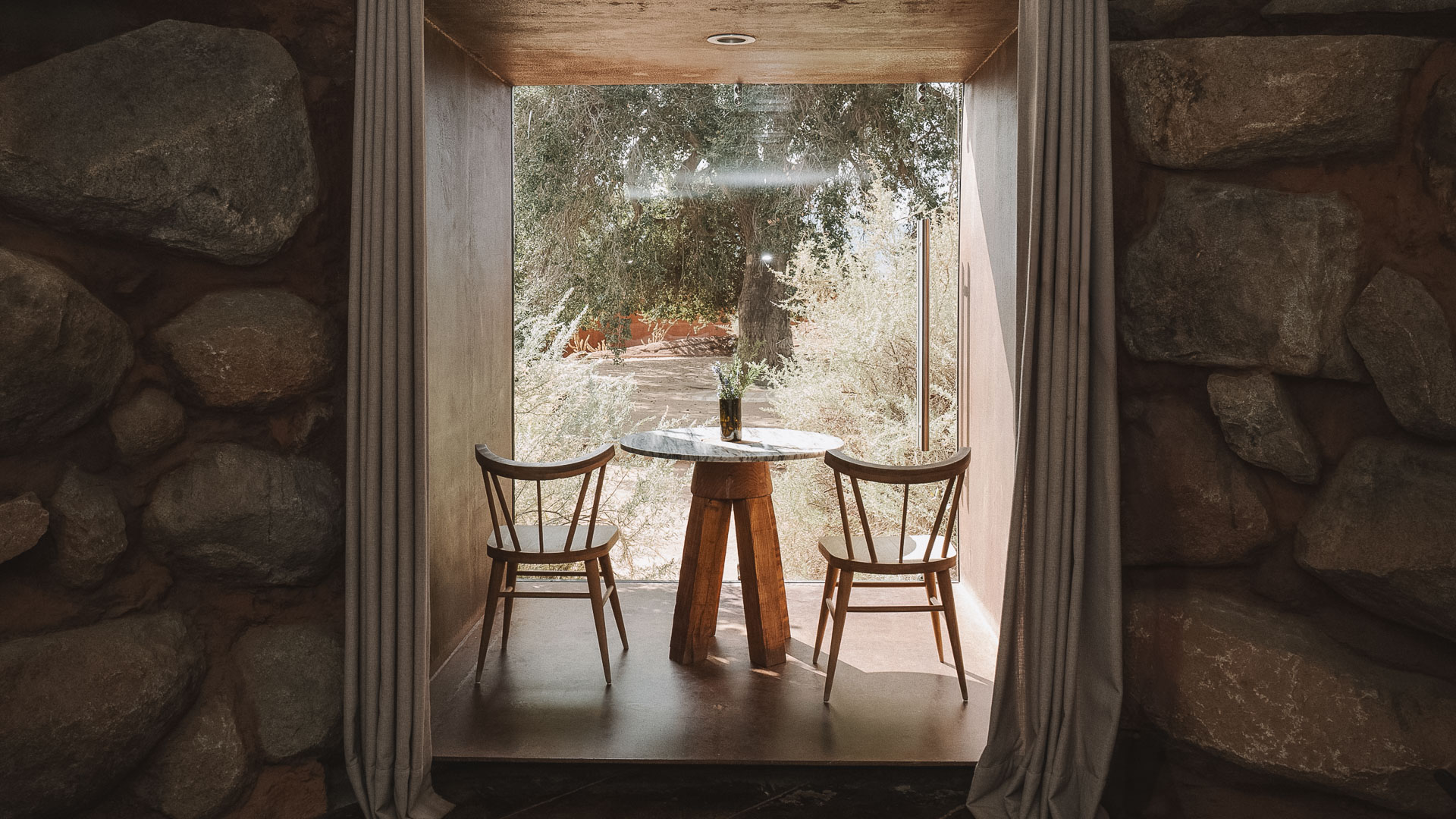 a table and chairs in a room with a window