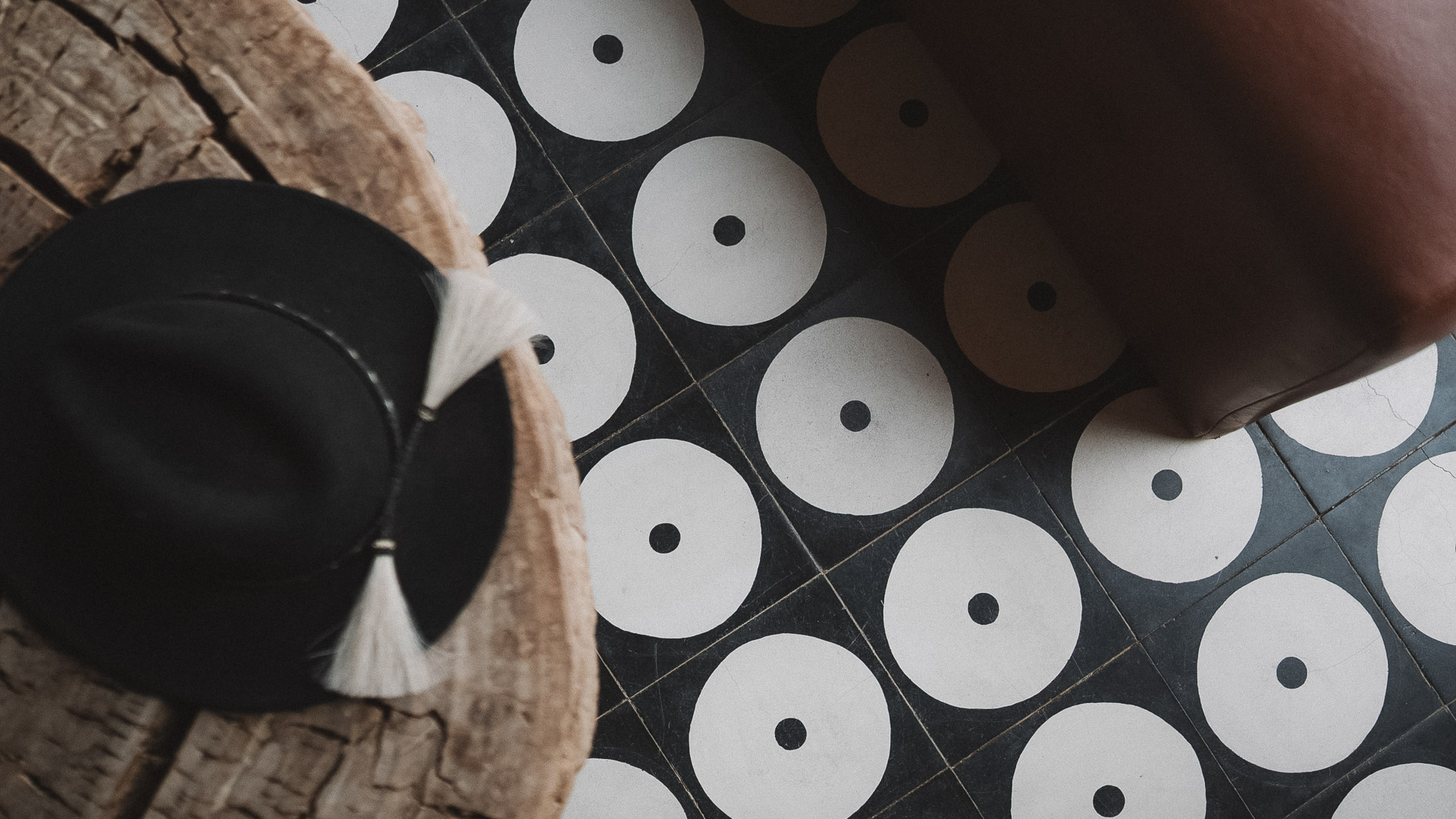 a black and white tile floor with a hat and white tassels