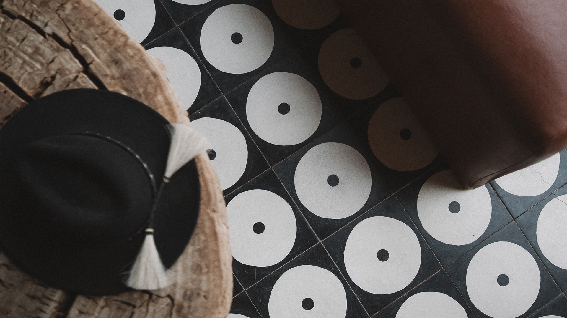 a black and white tile floor with a hat and white tassels