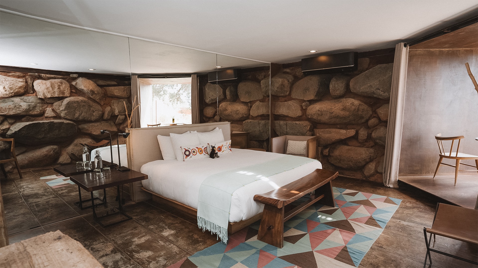 a room with a bed and a stone wall