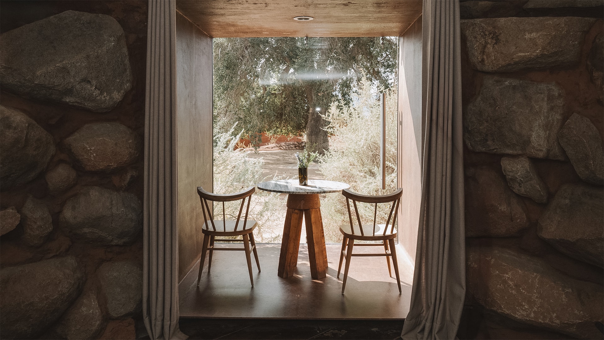 a table and chairs in a room with a window