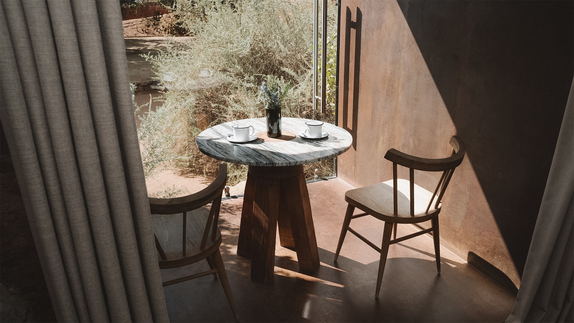 a table with two cups and a vase of flowers on it