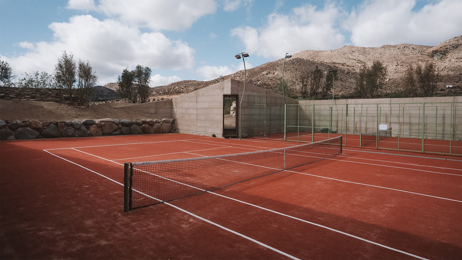 a tennis court with a stone wall and a stone wall