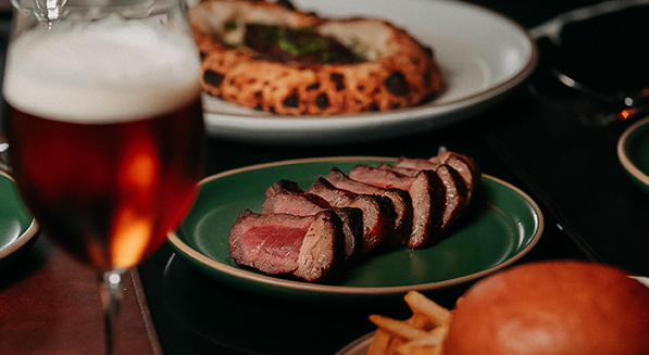 a plate of meat and a pizza