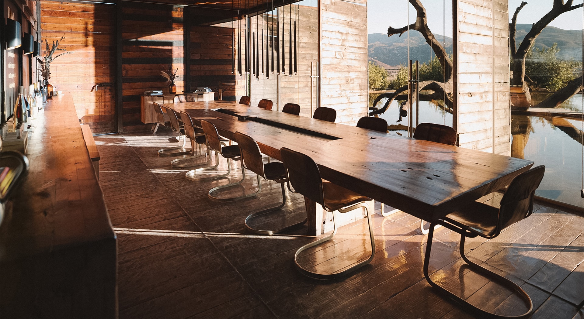 a long table with chairs in a room with a large window