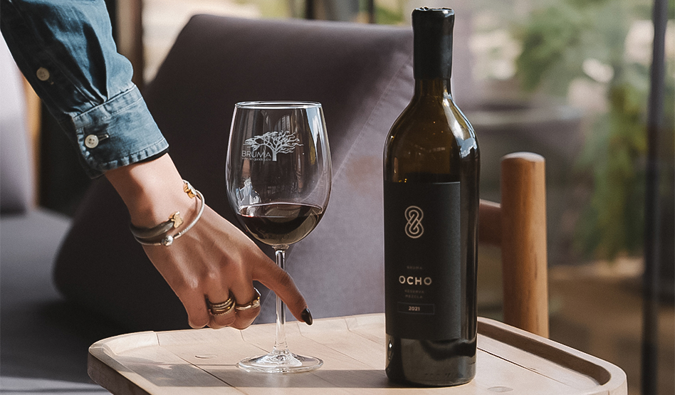 a hand pointing at a wine glass