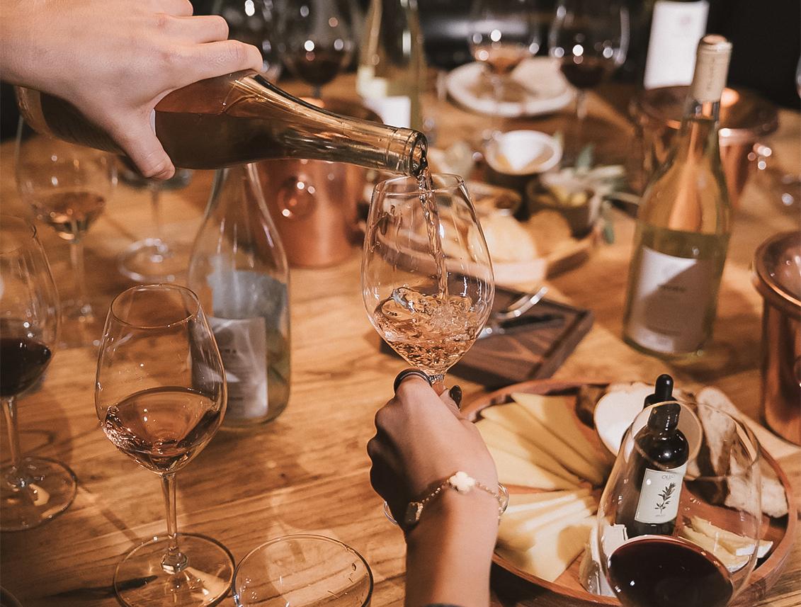 a person pouring wine into a glass