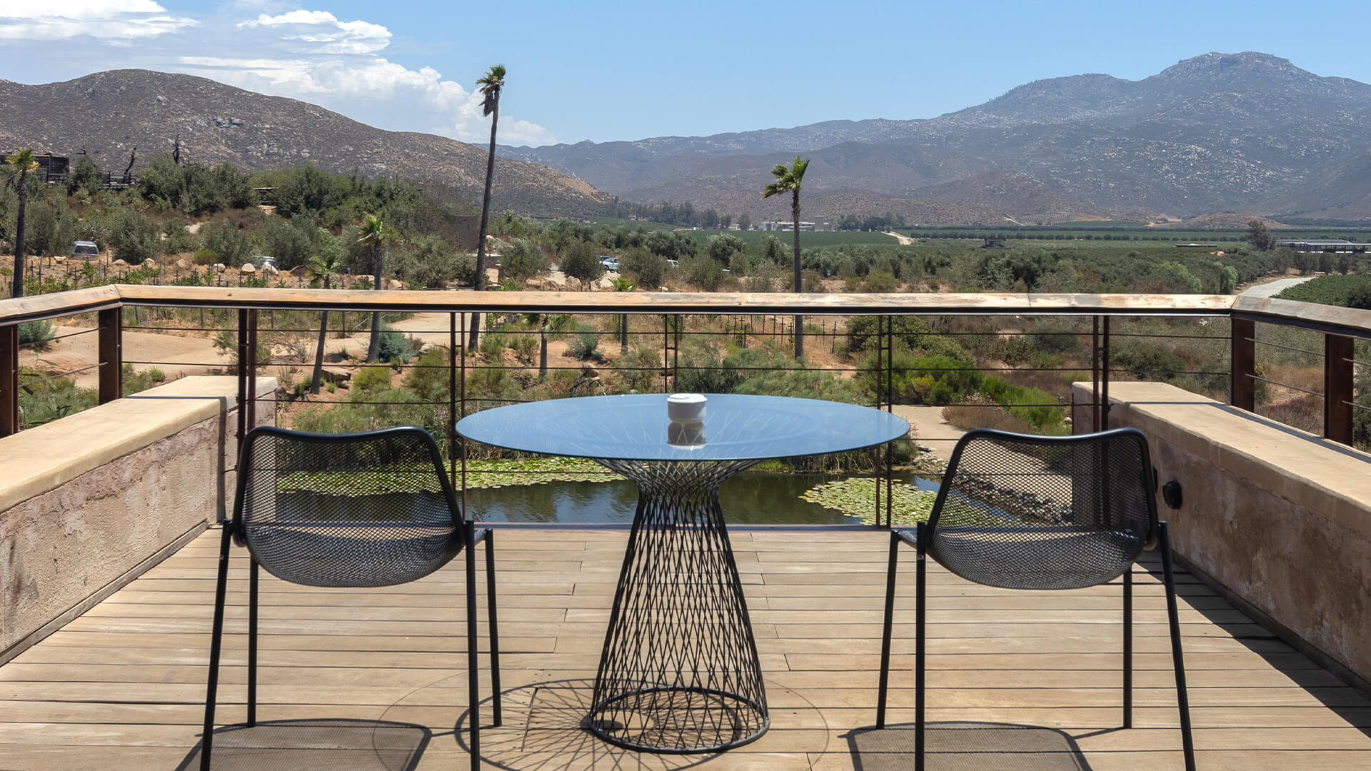 a table and chairs on a deck overlooking a valley