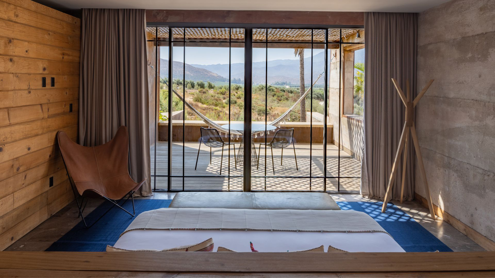 a room with a hammock and a view of the mountains