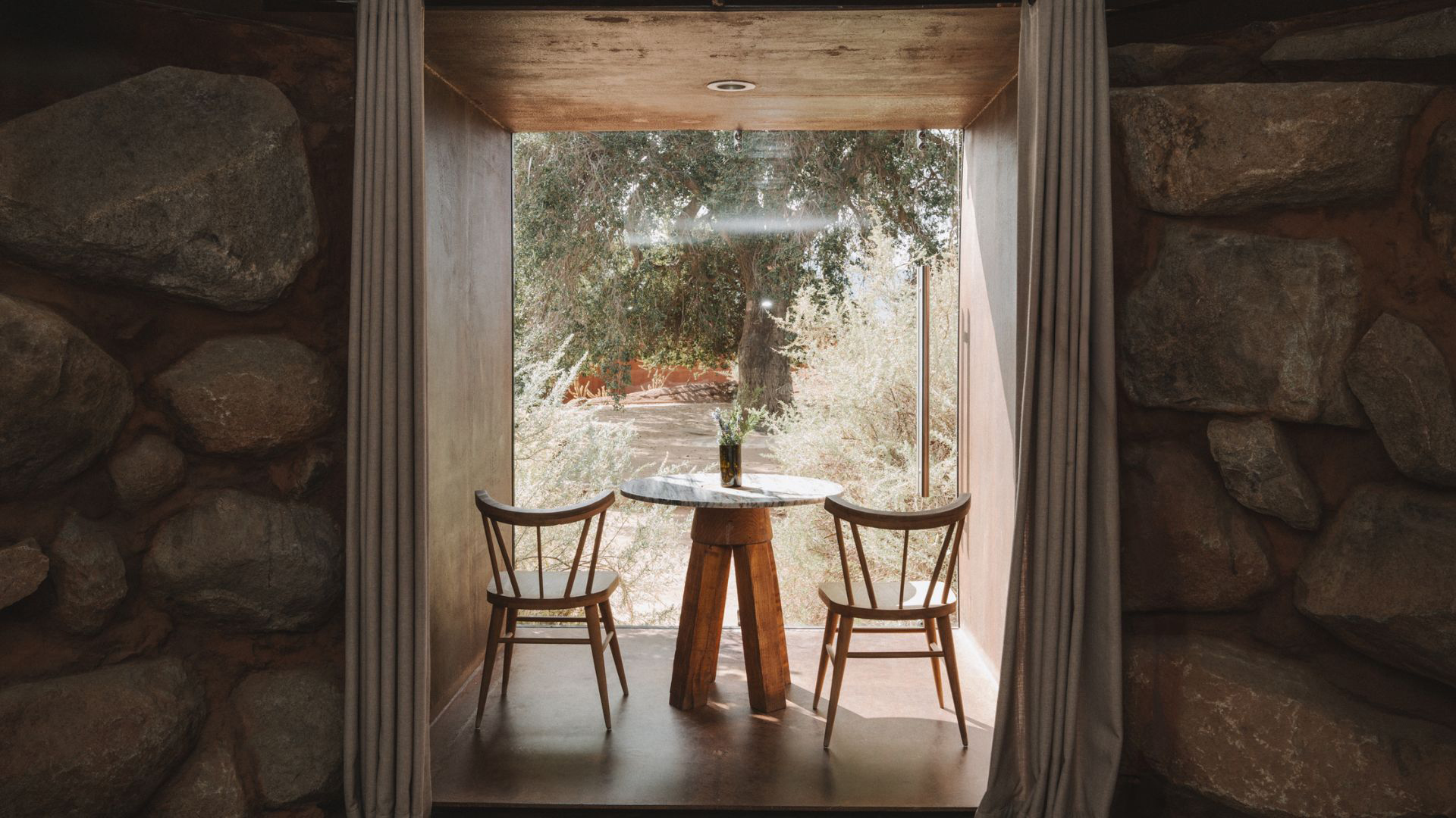 a table and chairs in a room with a window