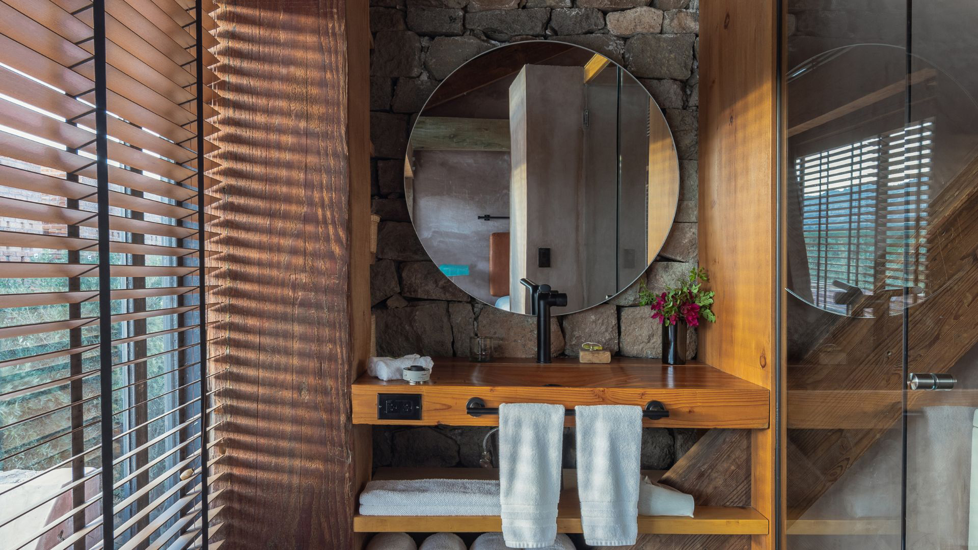 a bathroom with a round mirror and towels