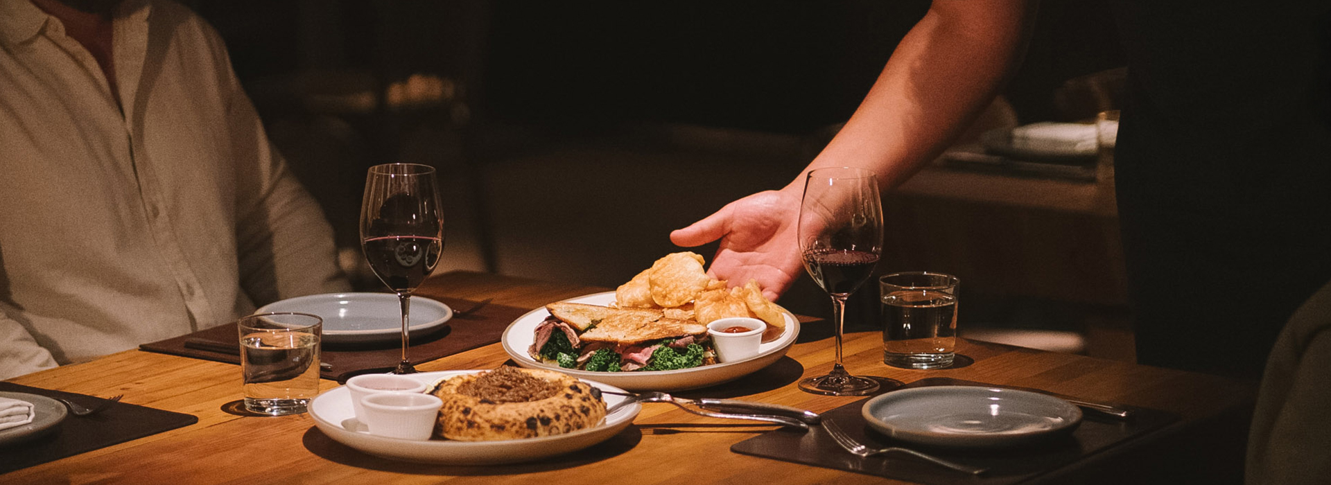 a hand reaching for a plate of food