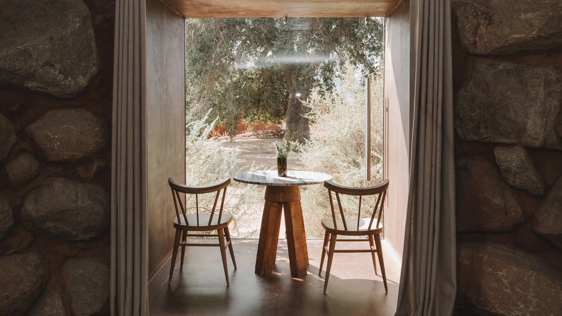 a table and chairs in a room with a window
