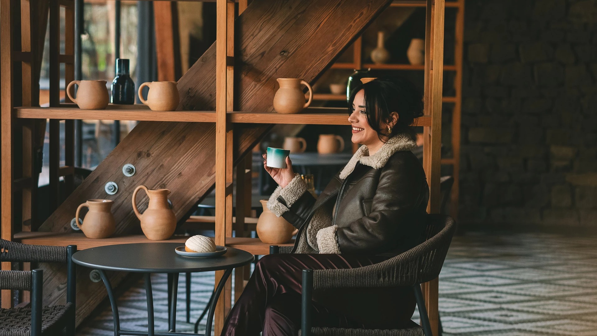 a woman sitting in a chair holding a cup