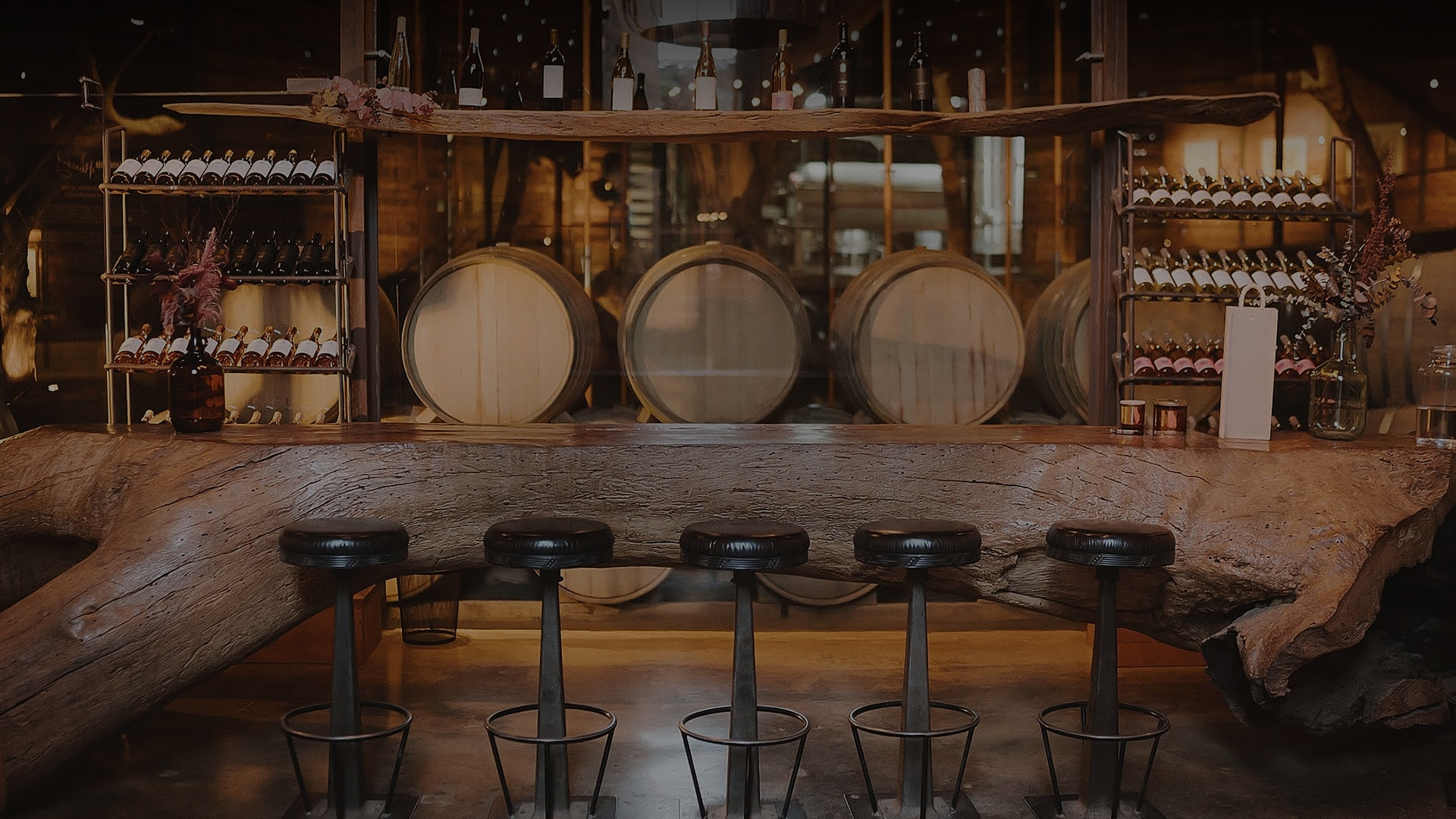 a bar with stools and barrels