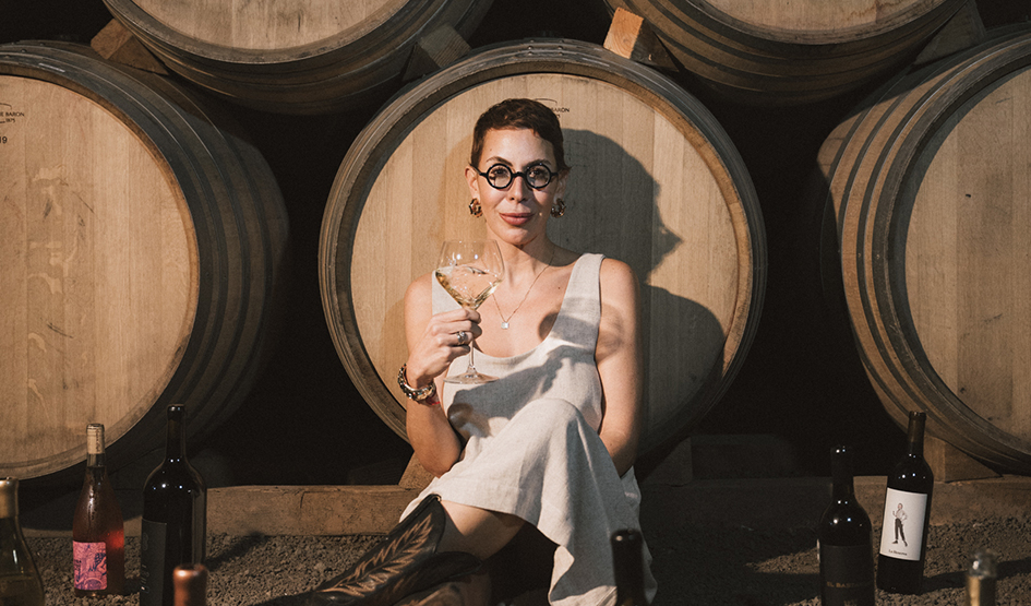 a woman sitting in front of a large barrel