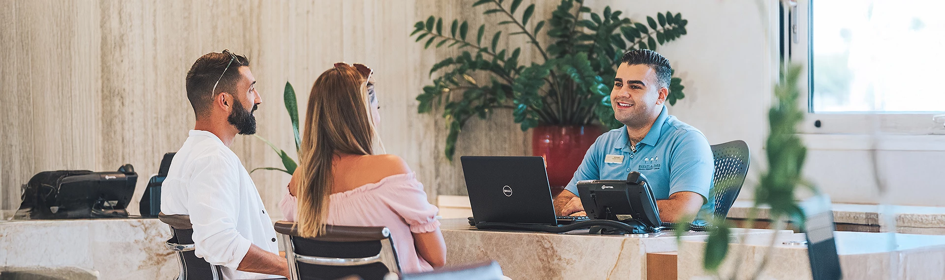 a man and woman sitting at a desk with laptops