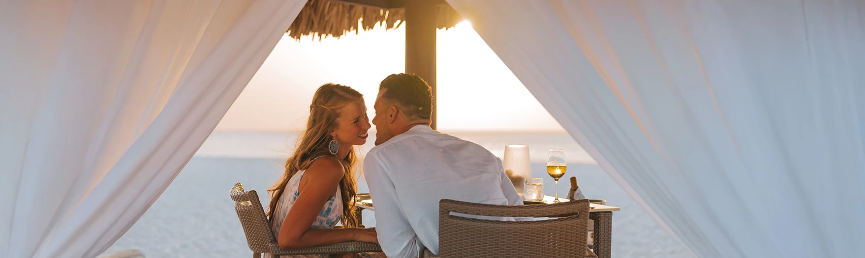 a man and woman sitting at a table with drinks
