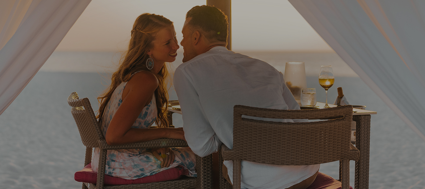 a man and woman sitting at a table with drinks