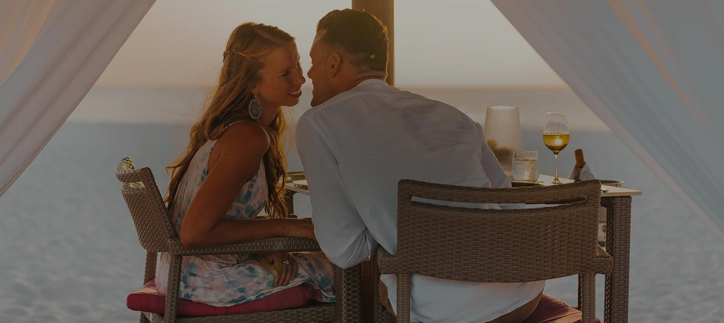 a man and woman sitting at a table with drinks