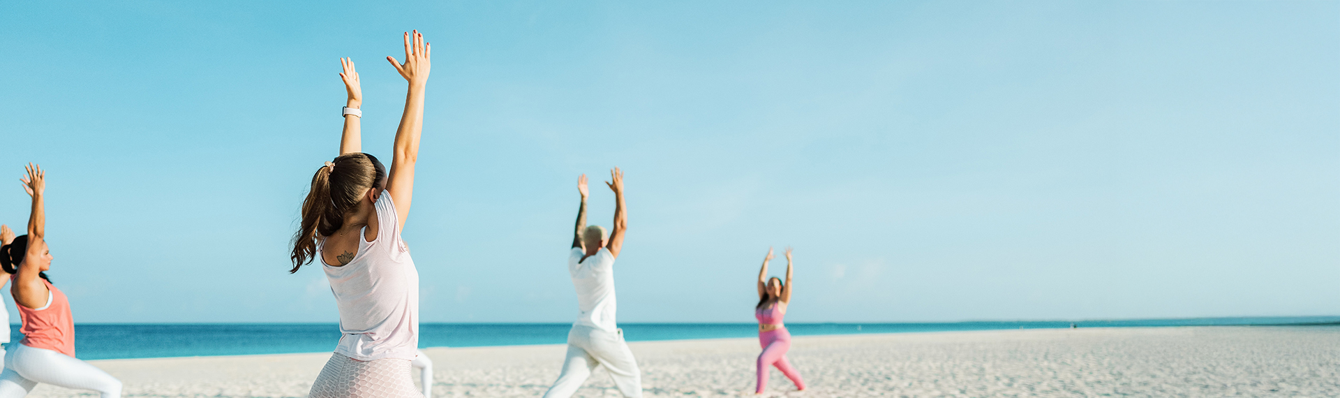a man and woman doing yoga on a beach