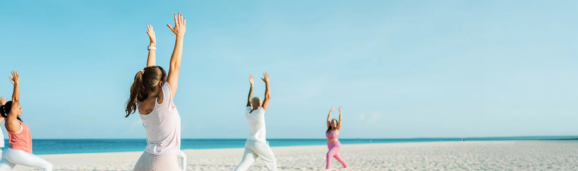 a man and woman doing yoga on a beach