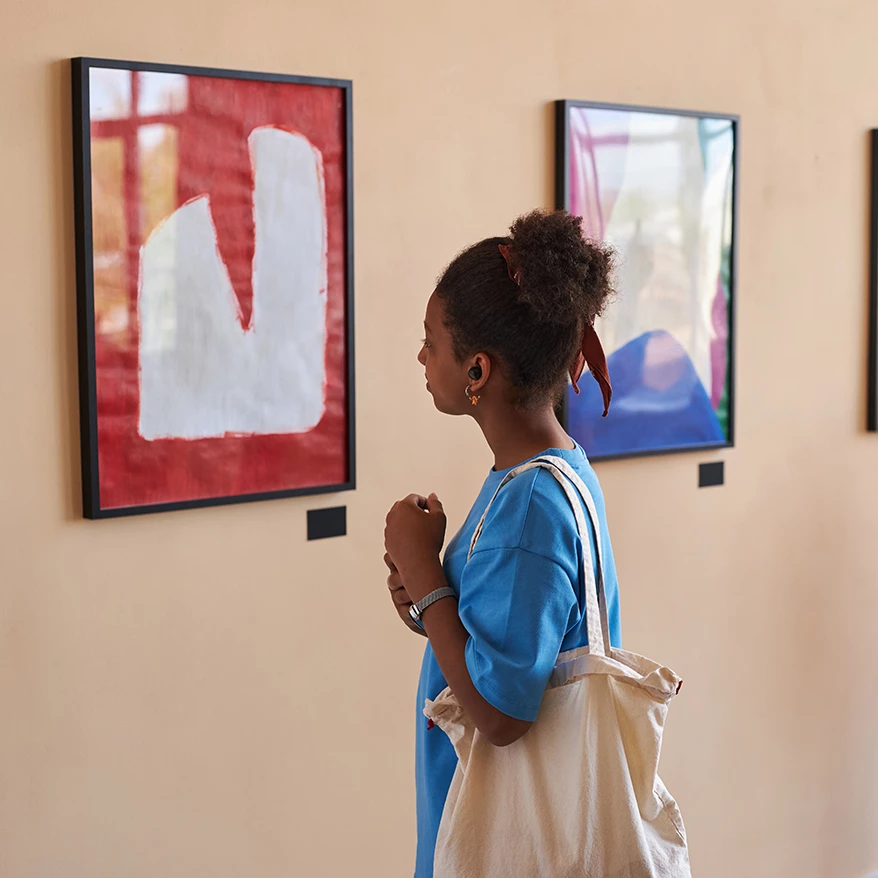a woman looking at art on the wall