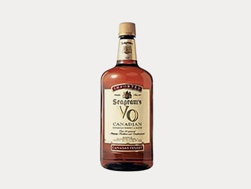a bottle of liquor with a white label with Jack Daniel&#39;s in the background