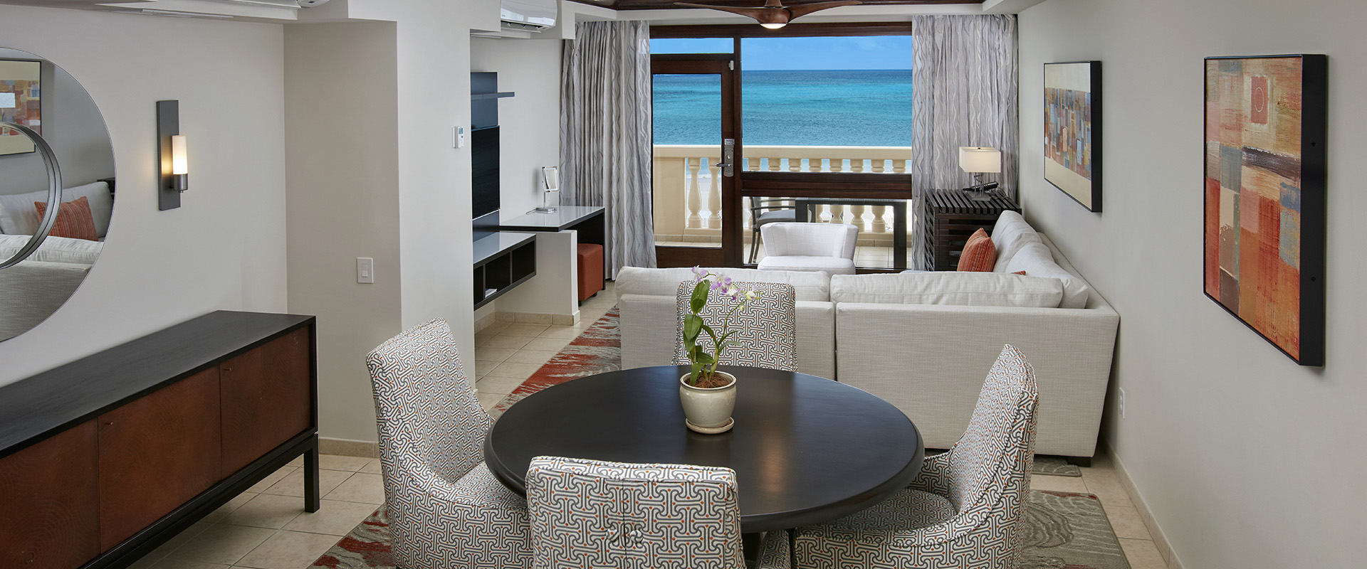 a room with a table and chairs and a view of the ocean