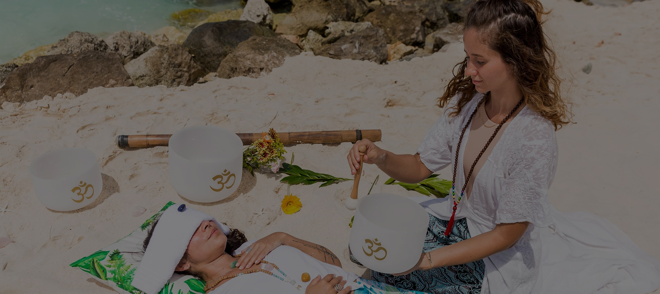 a woman playing with a drum on a beach