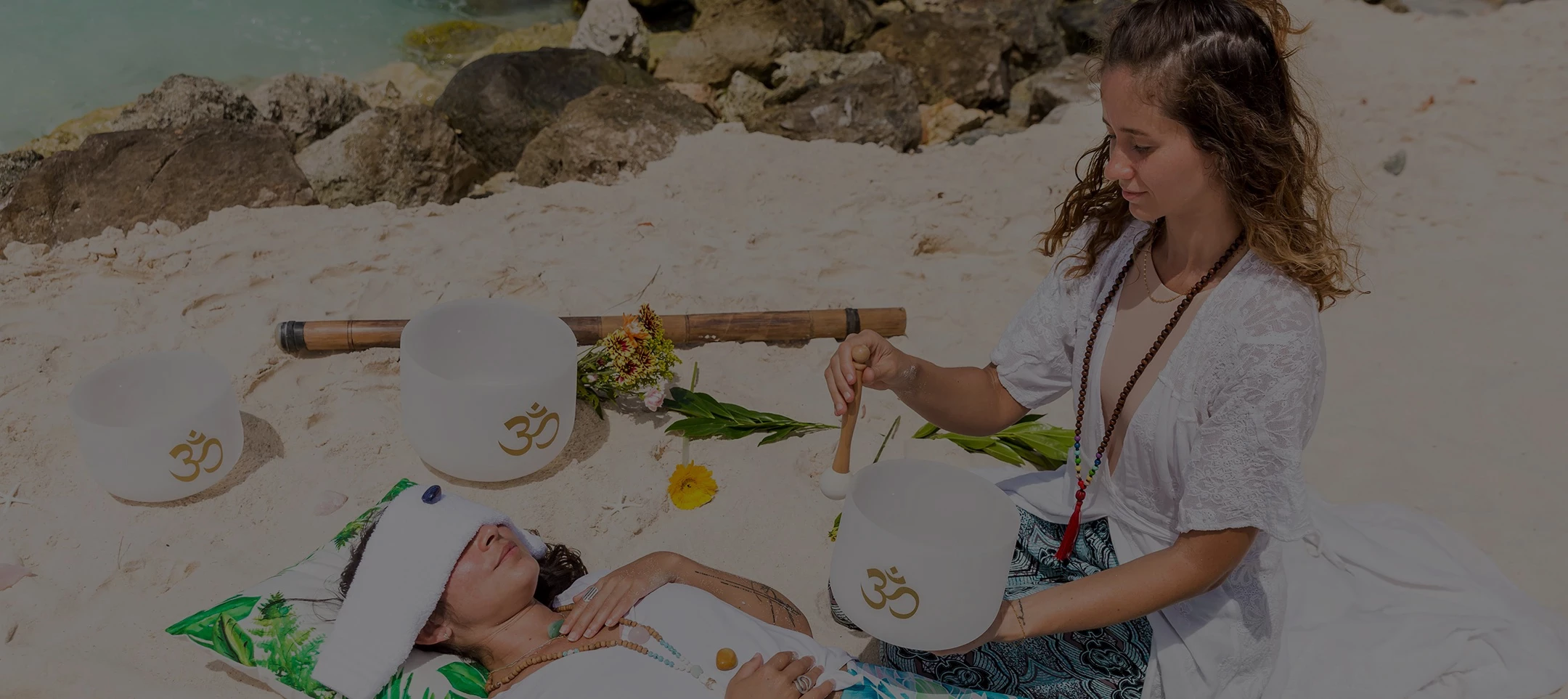 a woman playing with a drum on a beach