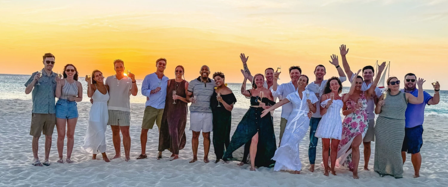 a group of people posing for a photo on a beach