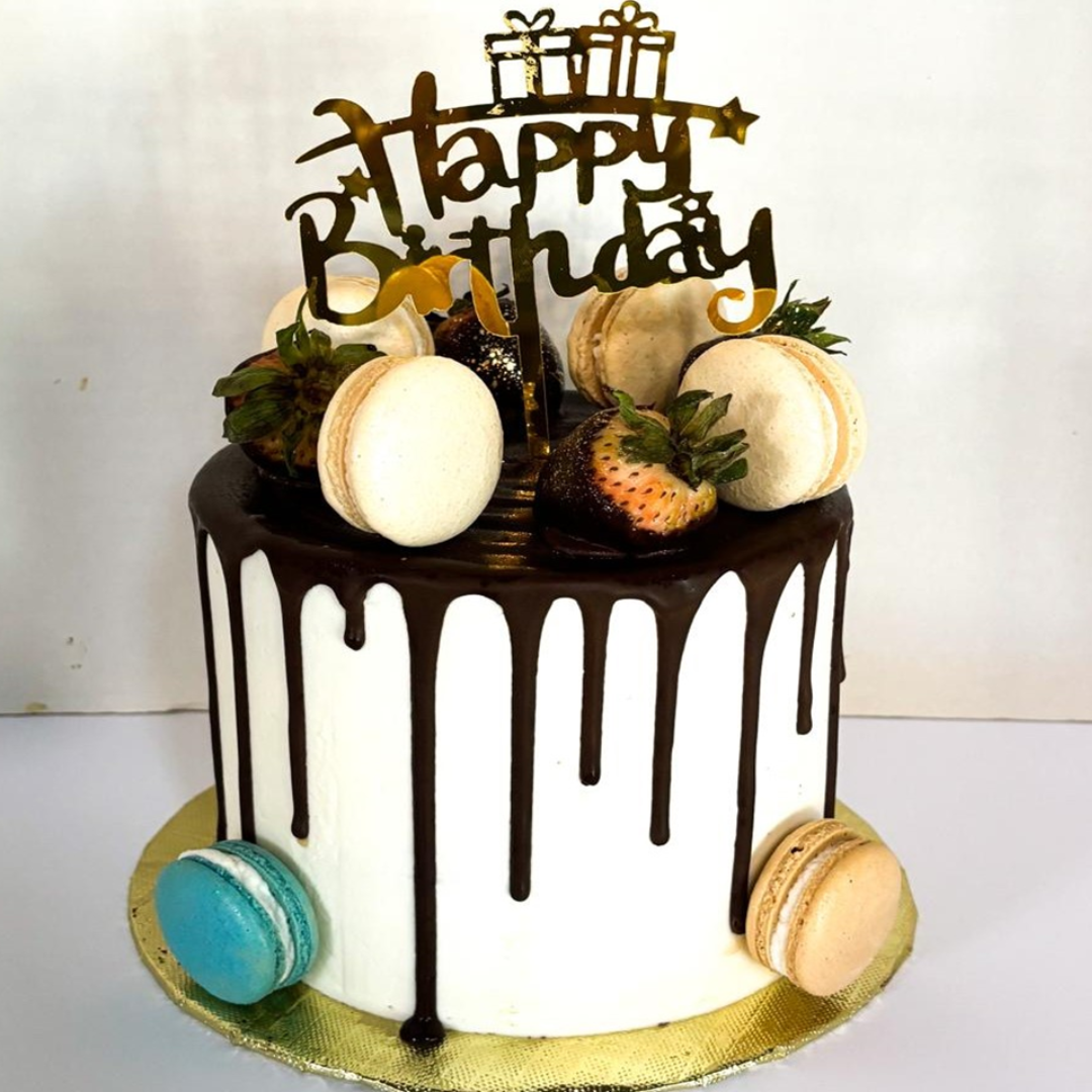 a cake with chocolate drips and macaroons