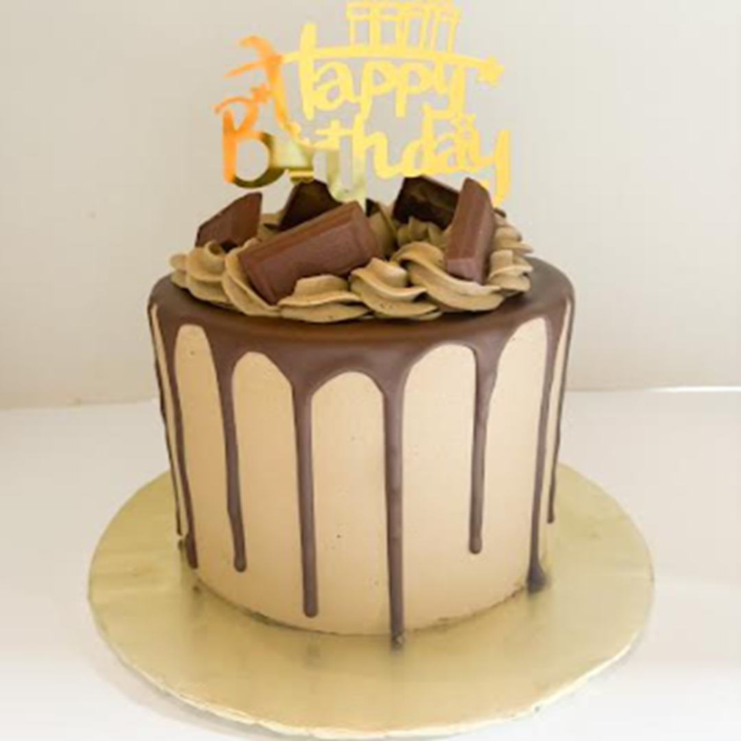 a cake with chocolate drips and a gold topper