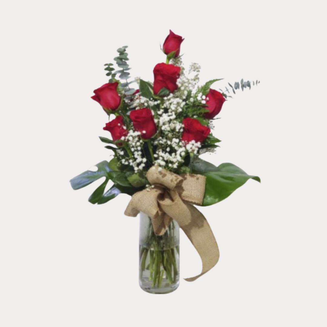 a vase with red roses and white flowers