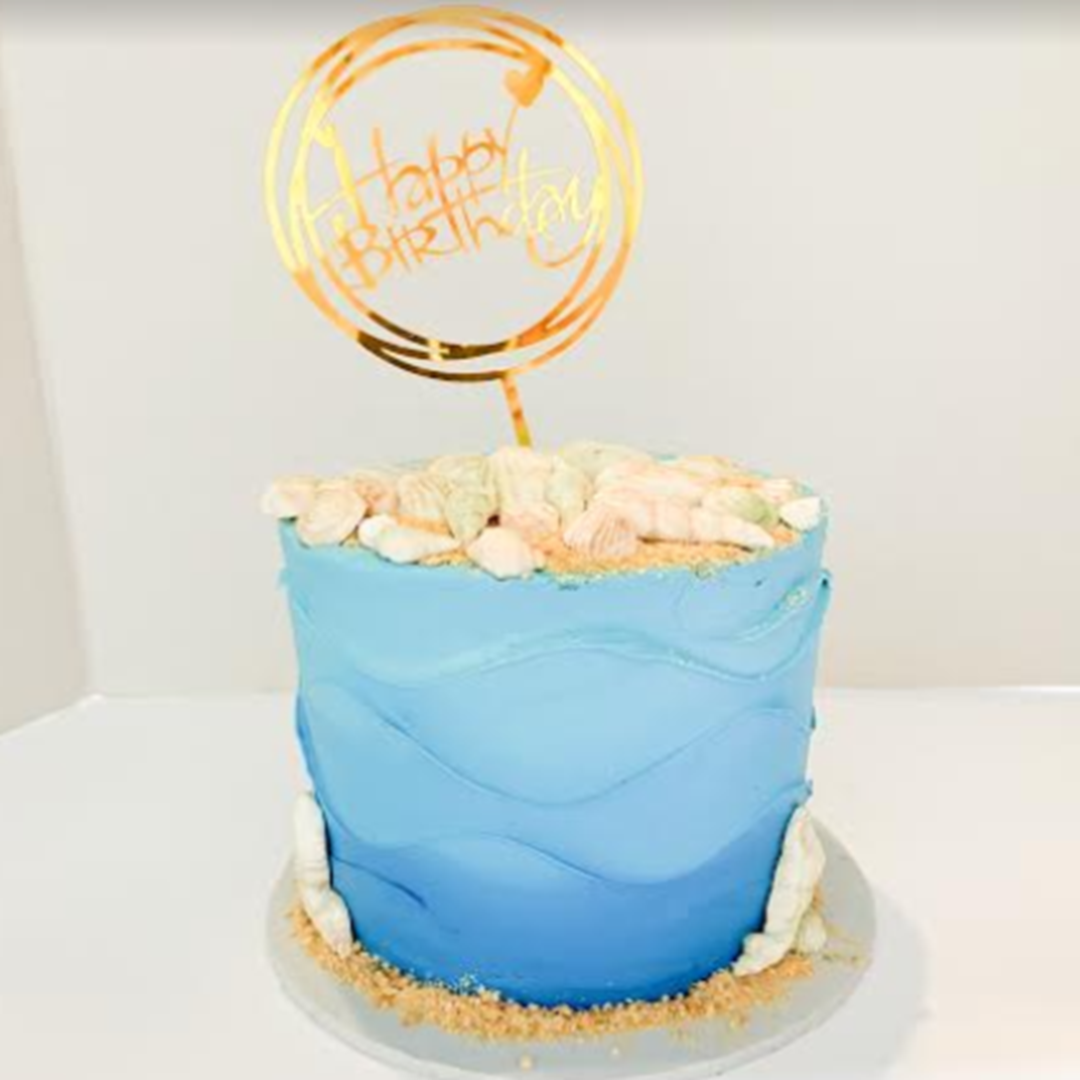 a blue cake with a gold topper