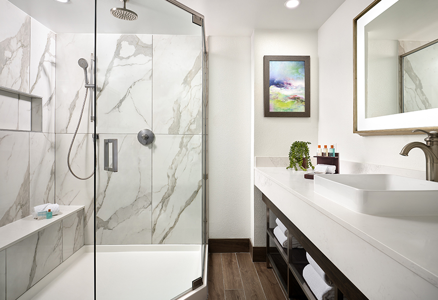 a bathroom with a glass shower and sink