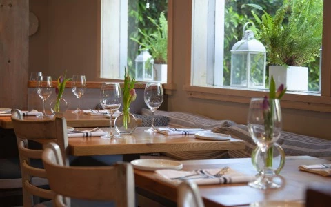 tables of a restaurant setup with a flowers in the center of the tables