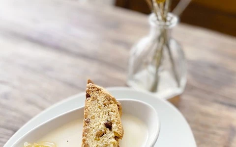 fancy soup served in a small white bowl with a sliced of bread on the top