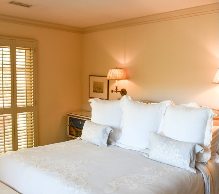 a bed with white pillows and lamps