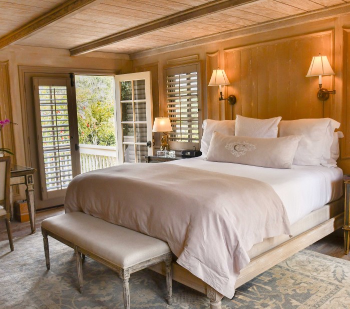 a bed with a bench and lamps